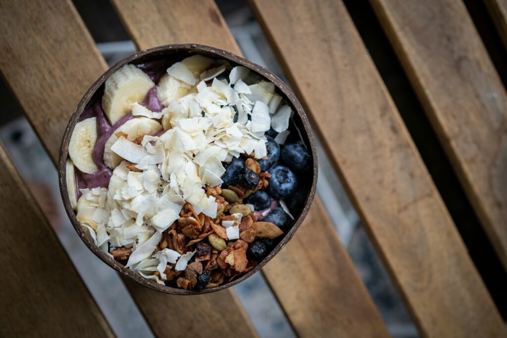 Coconut bowl filled with banana, granola, and berries for Healthy Breakfast in Brussels.