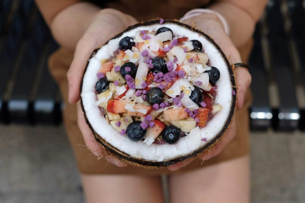 Tropical fruit mix in a coconut shell, ideal for Healthy Food for Businesses meals.