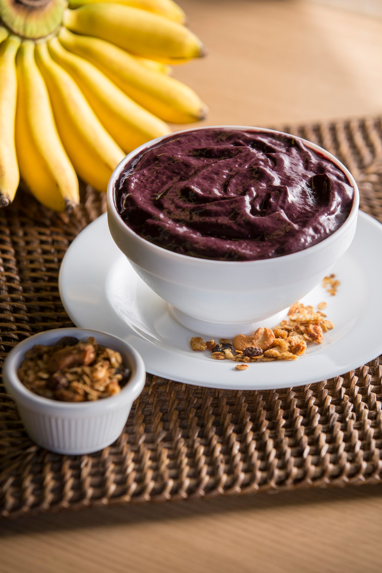 Organic açaí bowl with banana and crunchy granola on a white plate – healthy superfood breakfast