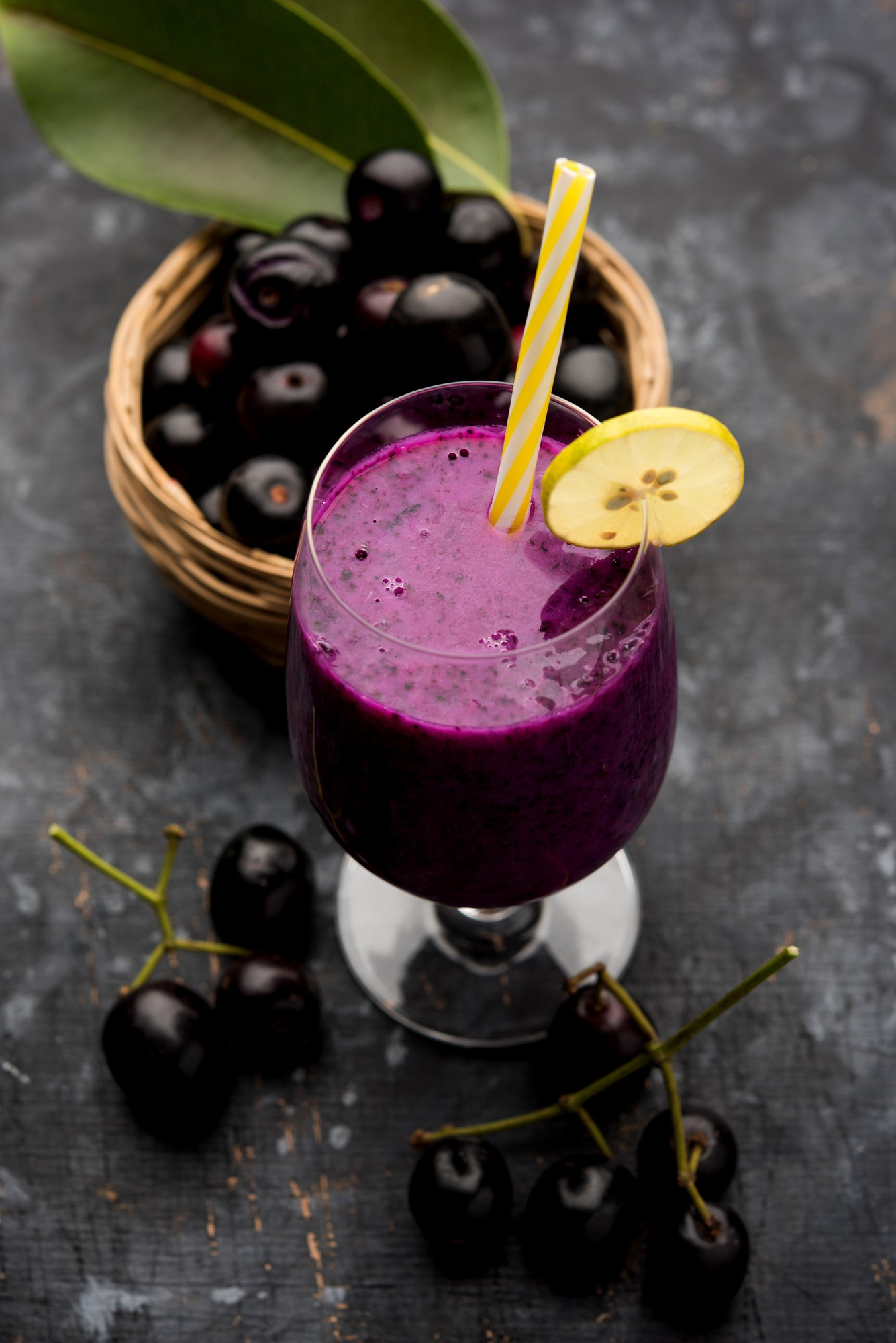 Glass of açaí smoothie with lemon slice and fresh berries – refreshing and energizing superfruit drink