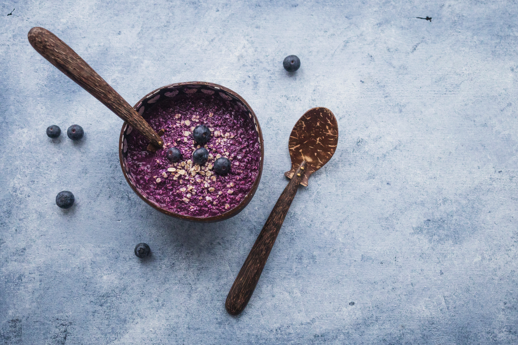Purple açaí bowl with blueberries and wooden spoon showcasing certification bio food standards for superfood preparation