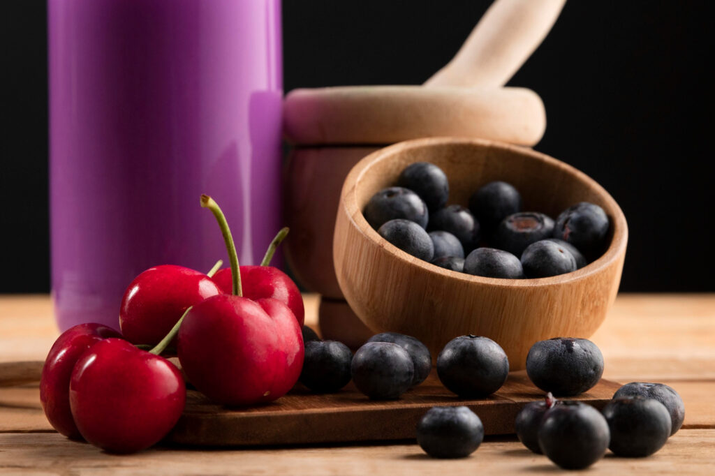 Fresh cherries and blueberries in wooden bowls demonstrating certification bio food quality ingredients for healthy restaurants