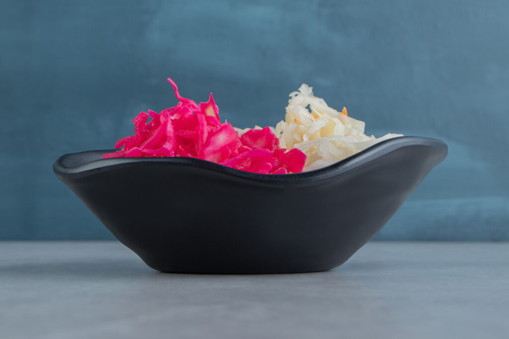 Modern açaí gastronomy presentation in sleek black bowl displaying vibrant pink and white açaí preparations with artistic plating technique