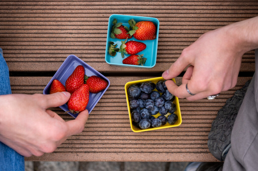 Individual organic fruit portions in colorful containers for healthy food delivery home service