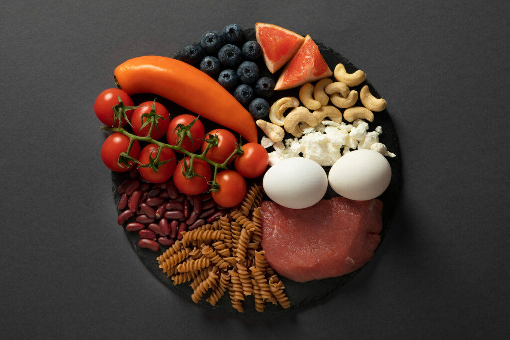 Microbiome diet brain-shaped plate with blueberries, grapefruit, cashews, eggs, tomatoes and whole grains representing gut-brain connection